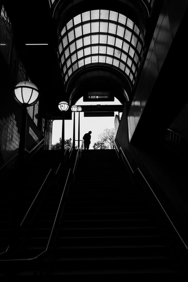 A man coming down the stairs in a train station